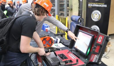 A student tries a welding simulator at the Trades Promoting Trades event at Lennox GS.