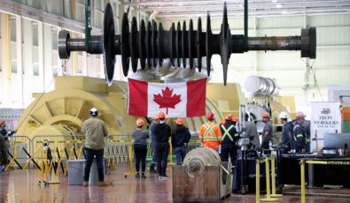 Students watch as a rotor from a turbine is raised by an overhead crane at Lennox GS.