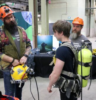 A student tries on diving gear at the Trades Promoting Trades event at OPG's Lennox GS.