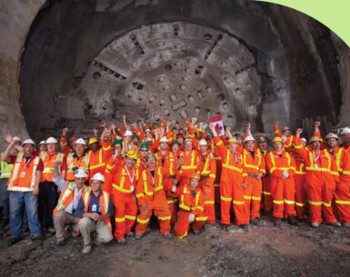 Employees working on the new hydro tunnel project gather at the opening to celebrate its completion.