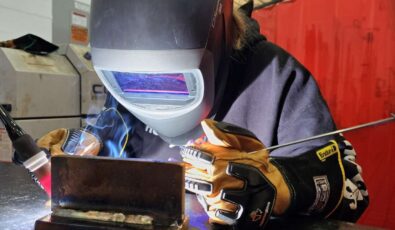 A student tries out a welding demonstration during a "Women in Trades" event.