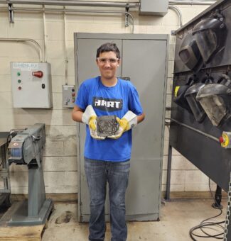 A student at the Mind Over Metal camp shows off his welding creation.