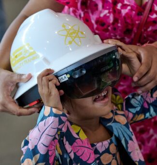 A young visitor tries out a pair of augmented reality training glasses at OPG's 2024 Community Power Expo.