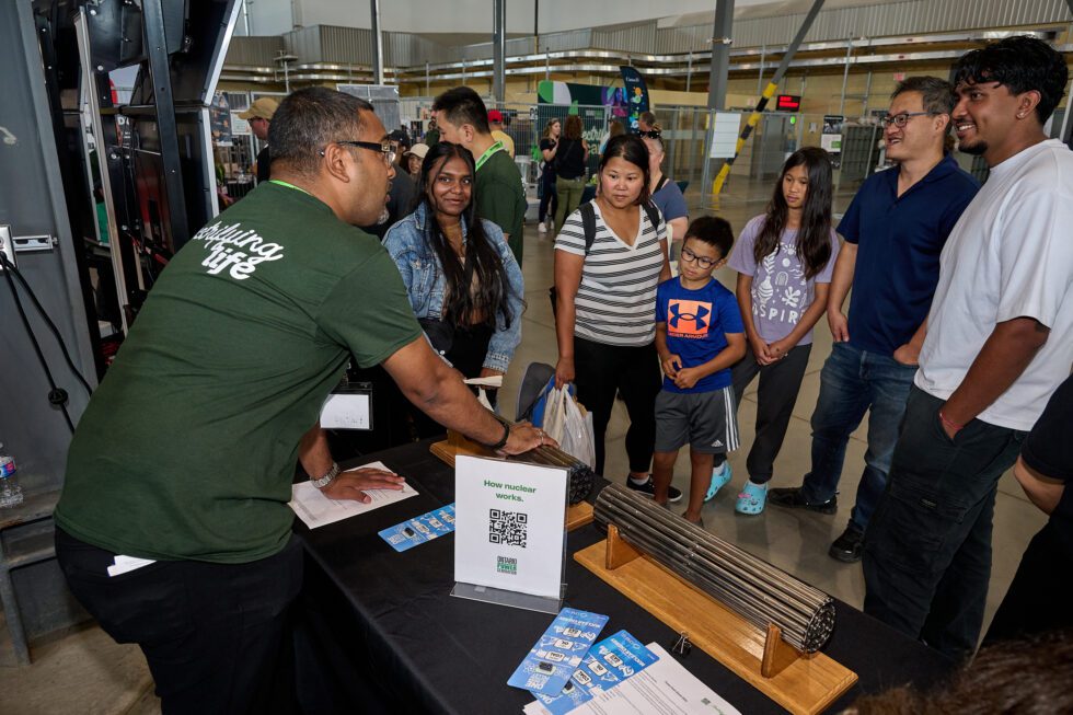 An OPG employee fields questions from the public at a community event.