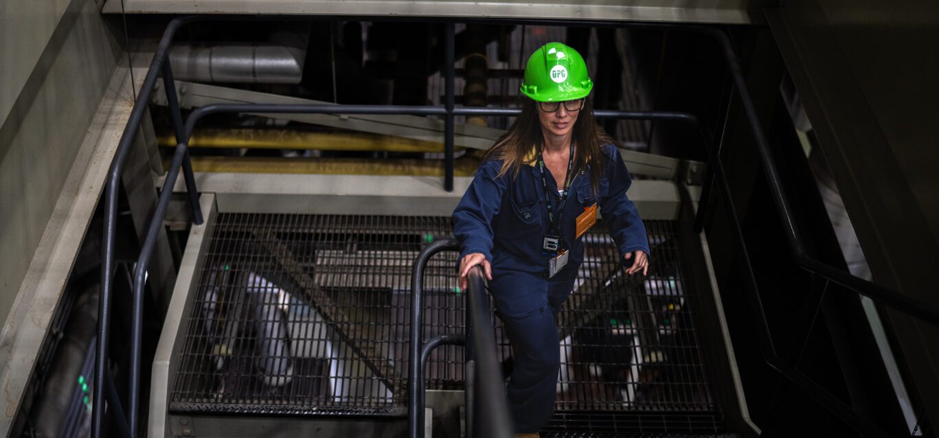 An OPG employee climbs stairs inside a generating facility