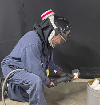 A worker at Darlington Nuclear demonstrates the laser blasting tool.