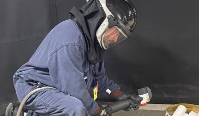 A worker at Darlington Nuclear demonstrates the laser blasting tool.